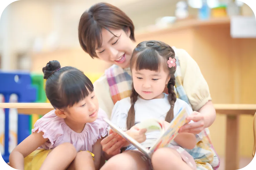 絵本を読む保育士と子どもたち